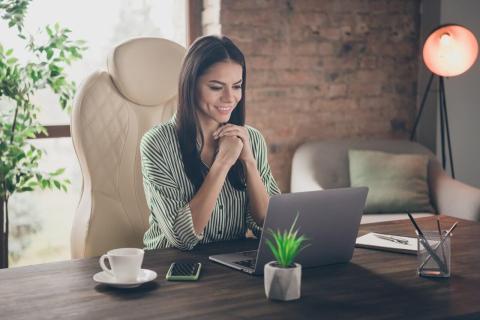 A job candidate recording a video resume on a laptop in a well-lit home office